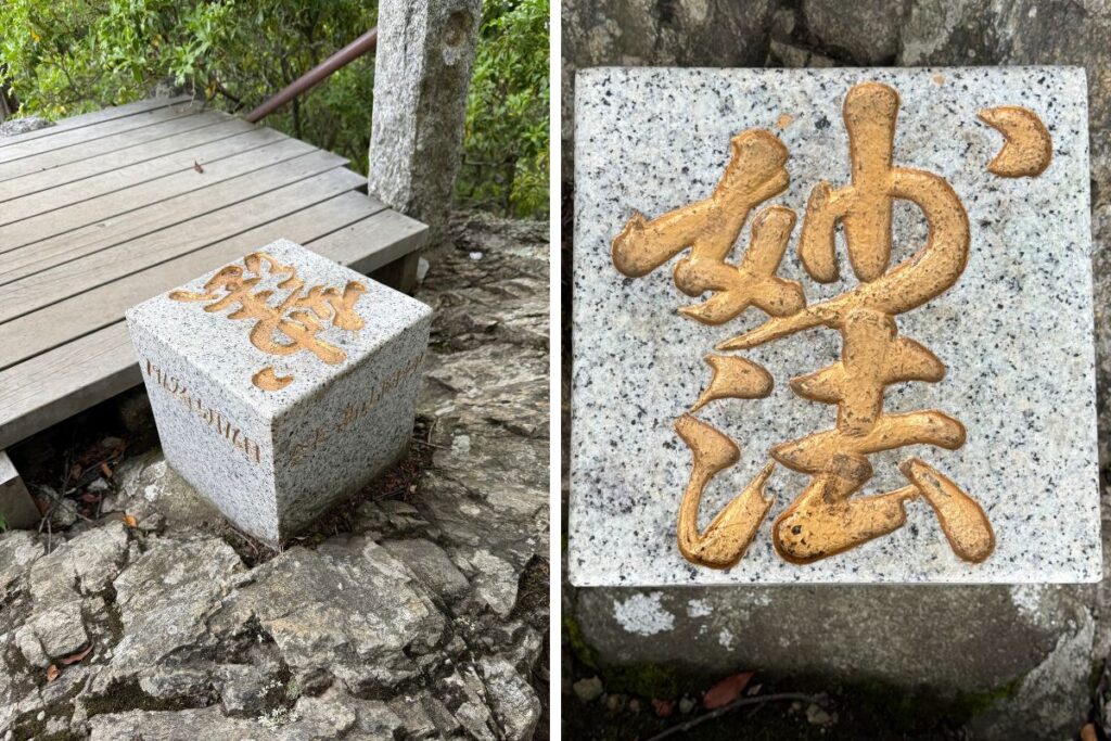 「妙法」と金文字で刻まれた石柱
